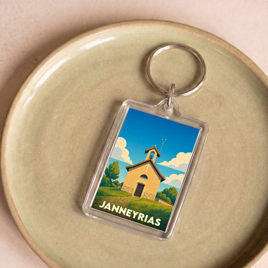 Porte-clés souvenir de la ville de Janneyrias avec une illustration stylisée d'une petite église sous un ciel bleu.