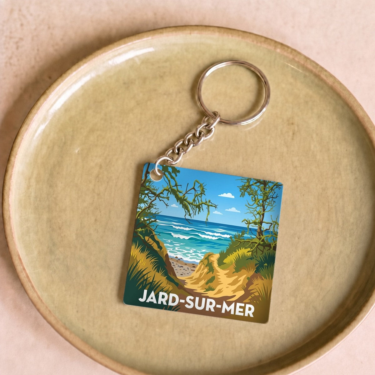Porte-clés souvenir de la ville de Jard-sur-Mer avec une illustration stylisée de son littoral.