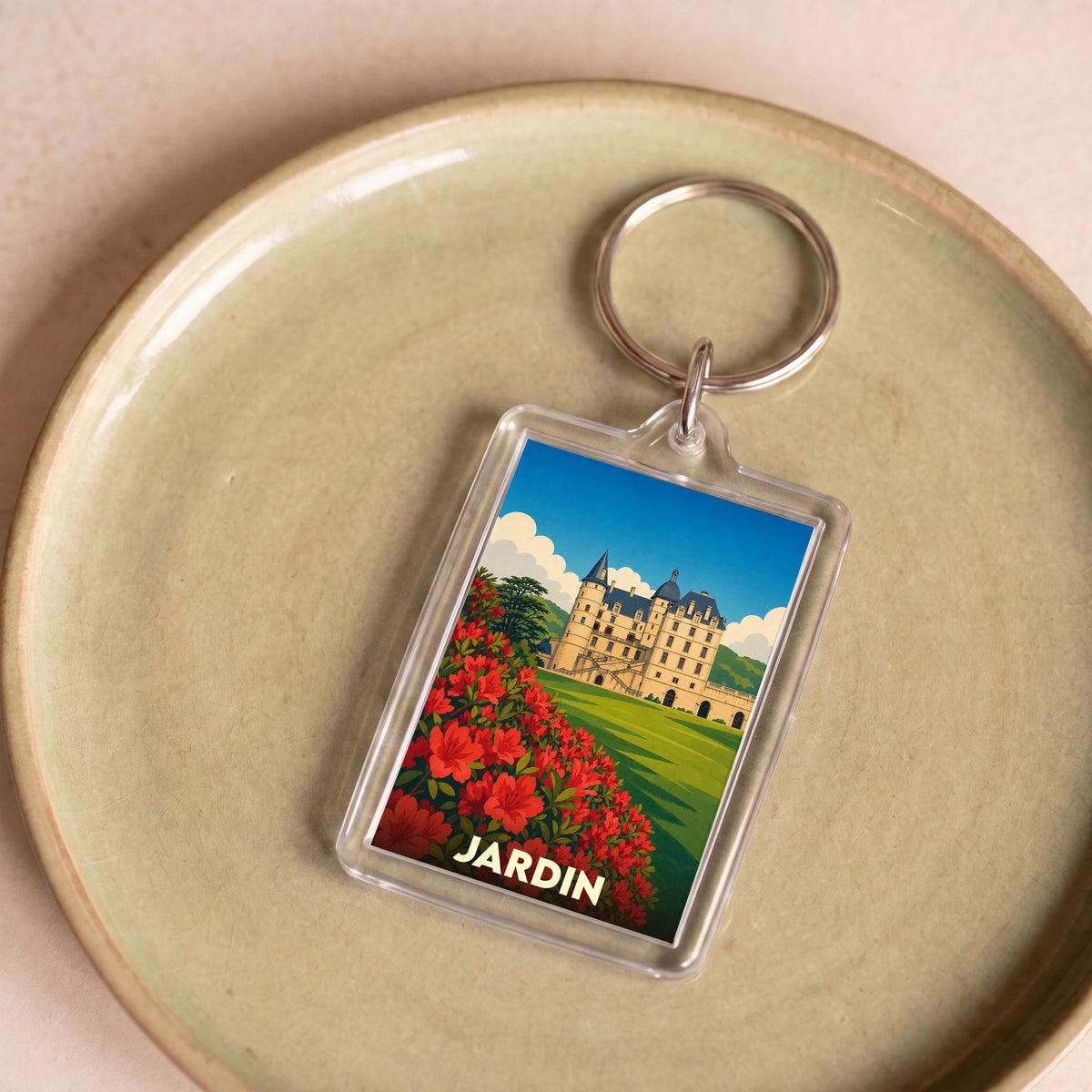 Porte-clés souvenir de la ville de Jardin avec une illustration stylisée d'un château et de fleurs rouges.