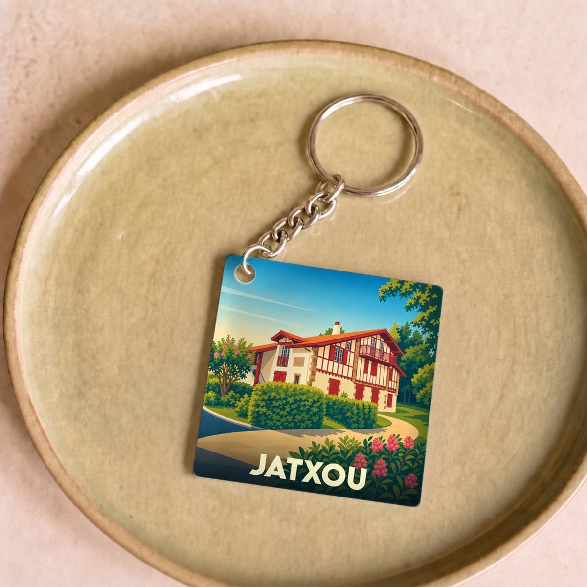 Porte-clés souvenir de la ville de Jatxou avec une illustration stylisée d'une maison basque.