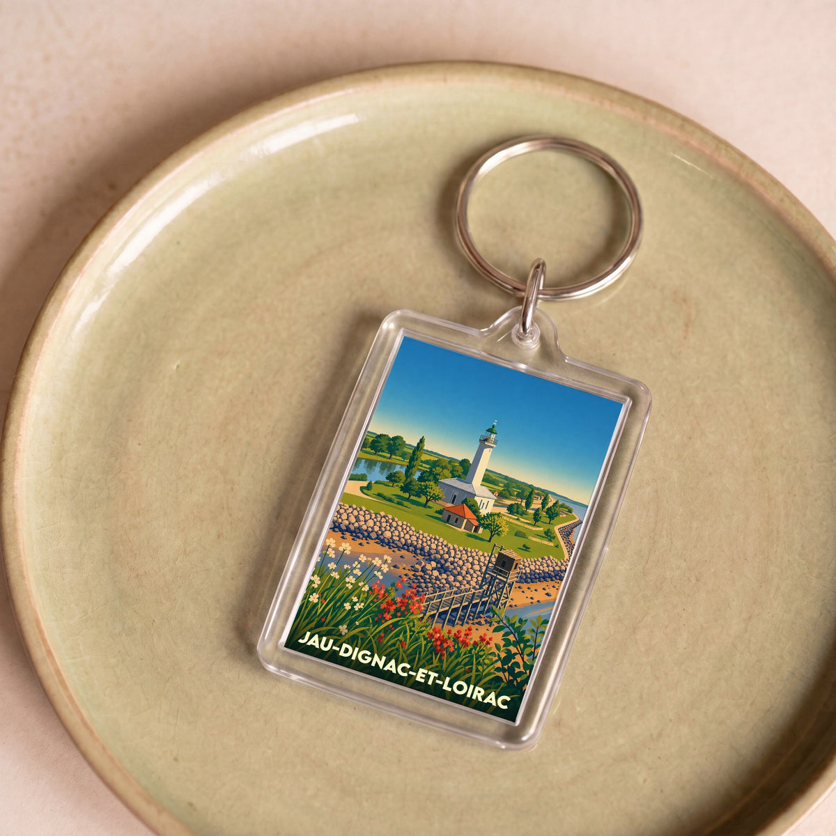Porte-clés souvenir de la ville de Jau-Dignac-et-Loirac avec une illustration stylisée de son phare.