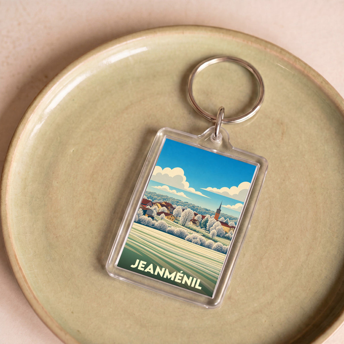Porte-clés souvenir de la ville de Jeanménil avec une illustration stylisée.