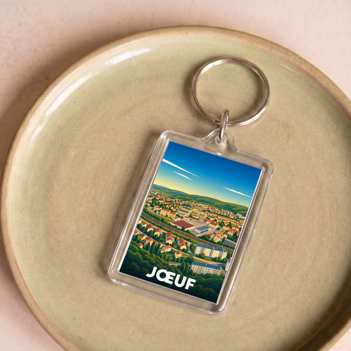 Porte-clés souvenir de la ville de Jœuf avec une illustration stylisée.