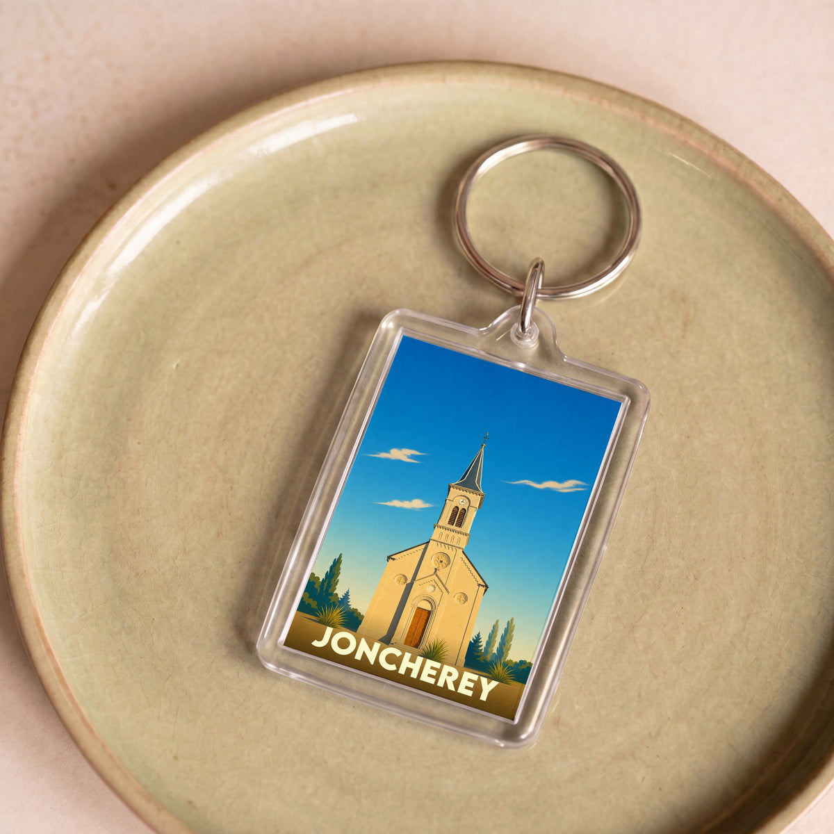 Porte-clés souvenir de la ville de Joncherey avec une illustration stylisée de son église.