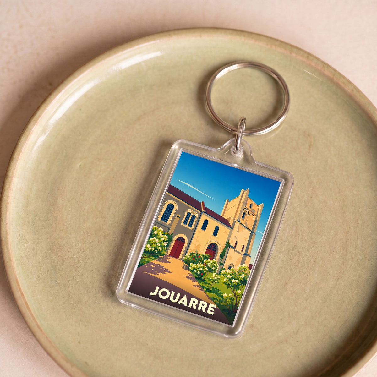 Porte-clés souvenir de la ville de Jouarre avec une illustration stylisée de son patrimoine.