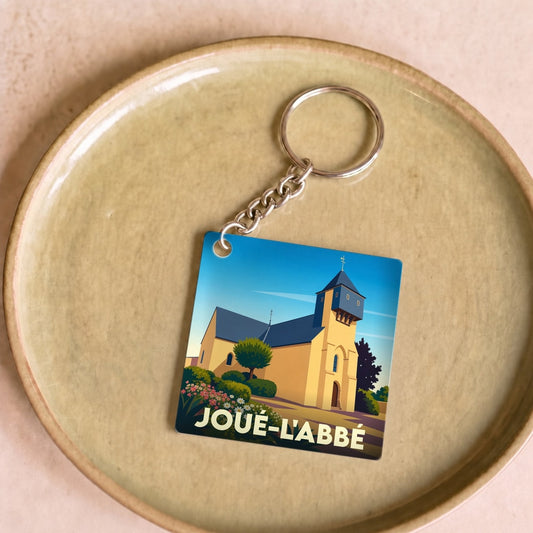 Porte-clés souvenir de la ville de Joué-l'Abbé avec une illustration stylisée de son église.