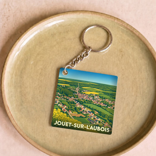 Porte-clés souvenir de la ville de Jouet-sur-l'Aubois avec une illustration stylisée.