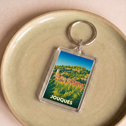 Porte-clés souvenir de la ville de Jouques avec une illustration stylisée.