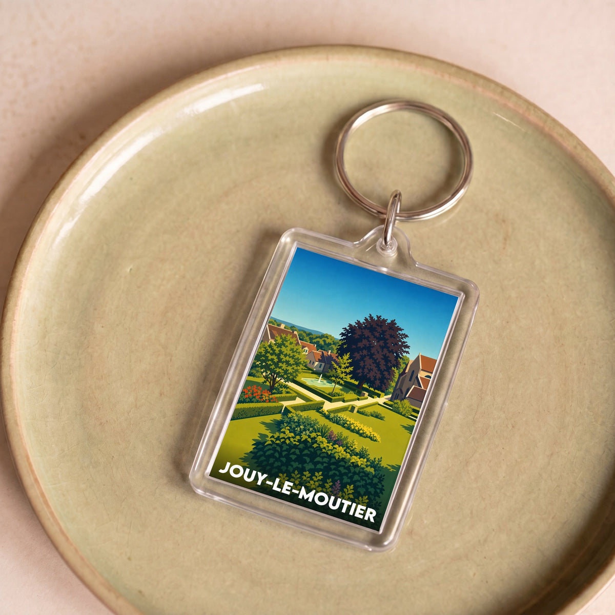 Porte-clés souvenir de la ville de Jouy-le-Moutier avec une illustration stylisée.