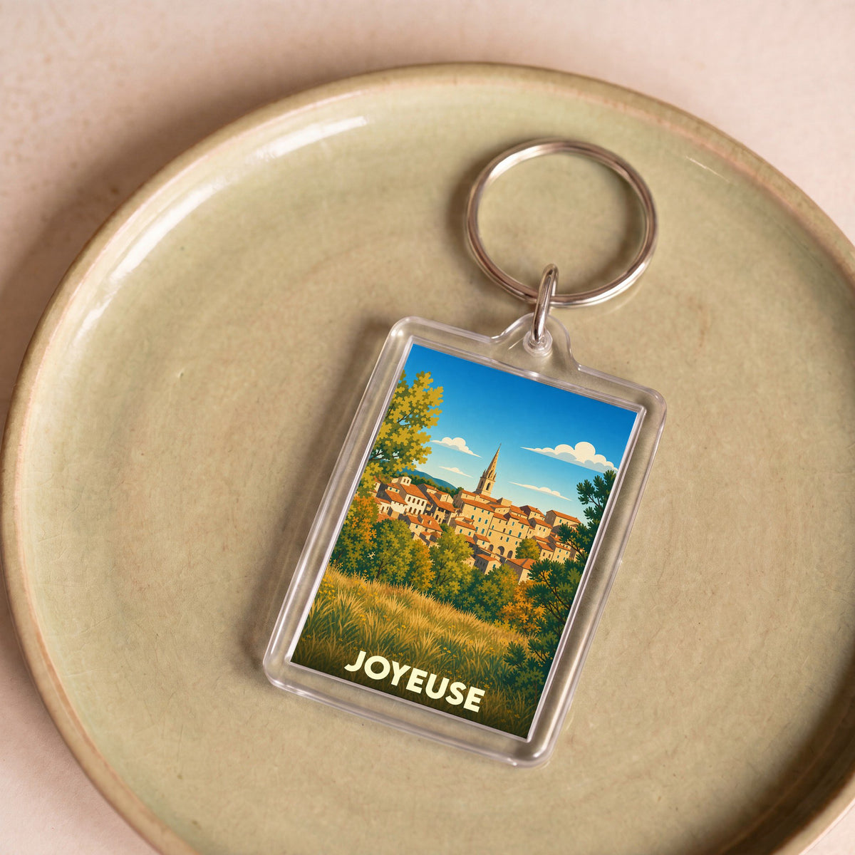 Porte-clés souvenir de la ville de Joyeuse avec une illustration stylisée.