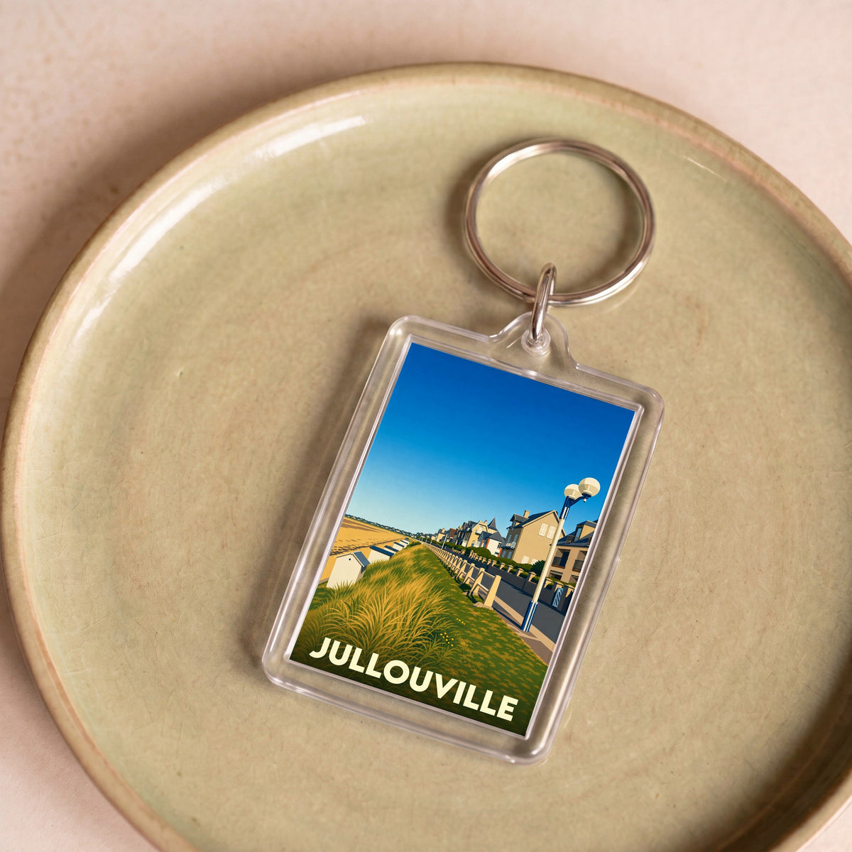 Porte-clés souvenir de la ville de Jullouville avec une illustration stylisée de son front de mer.
