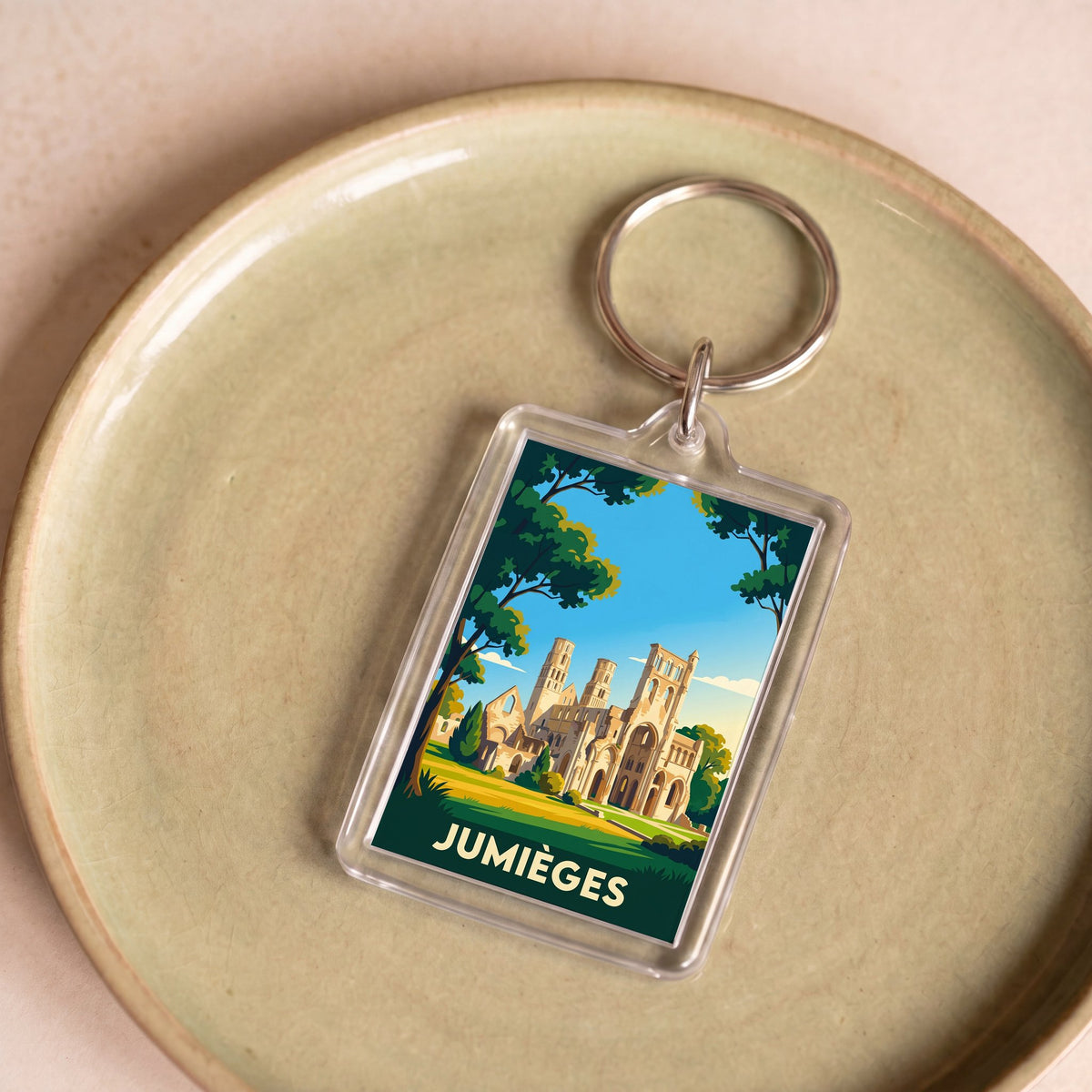 Porte-clés souvenir de la ville de Jumièges avec une illustration stylisée de son abbaye.