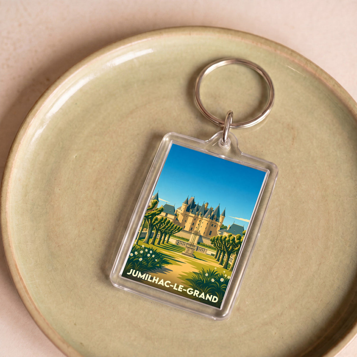 Porte-clés souvenir de la ville de Jumilhac-le-Grand avec une illustration stylisée de son château.