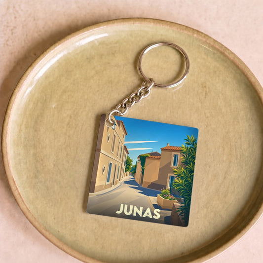Porte-clés souvenir de la ville de Junas avec une illustration stylisée d'une ruelle ensoleillée.