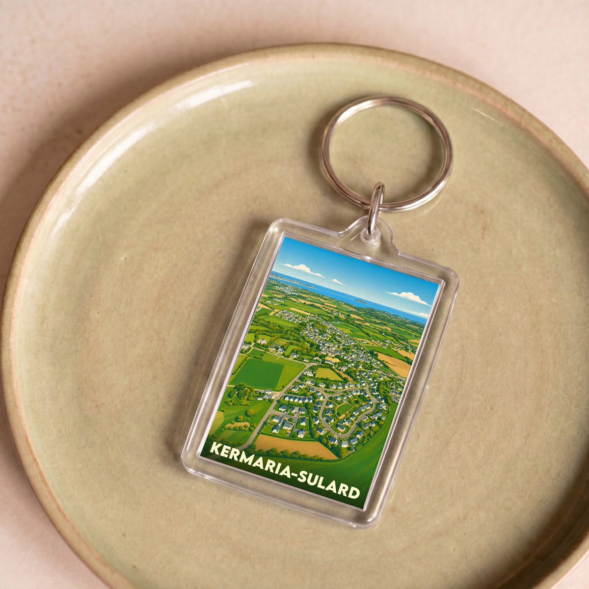 Porte-clés souvenir de la commune de Kermaria-Sulard avec une illustration stylisée vue du ciel.