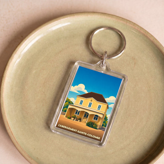 Porte-clés souvenir de la ville de L'Abergement-Sainte-Colombe avec une illustration stylisée d'une maison jaune.
