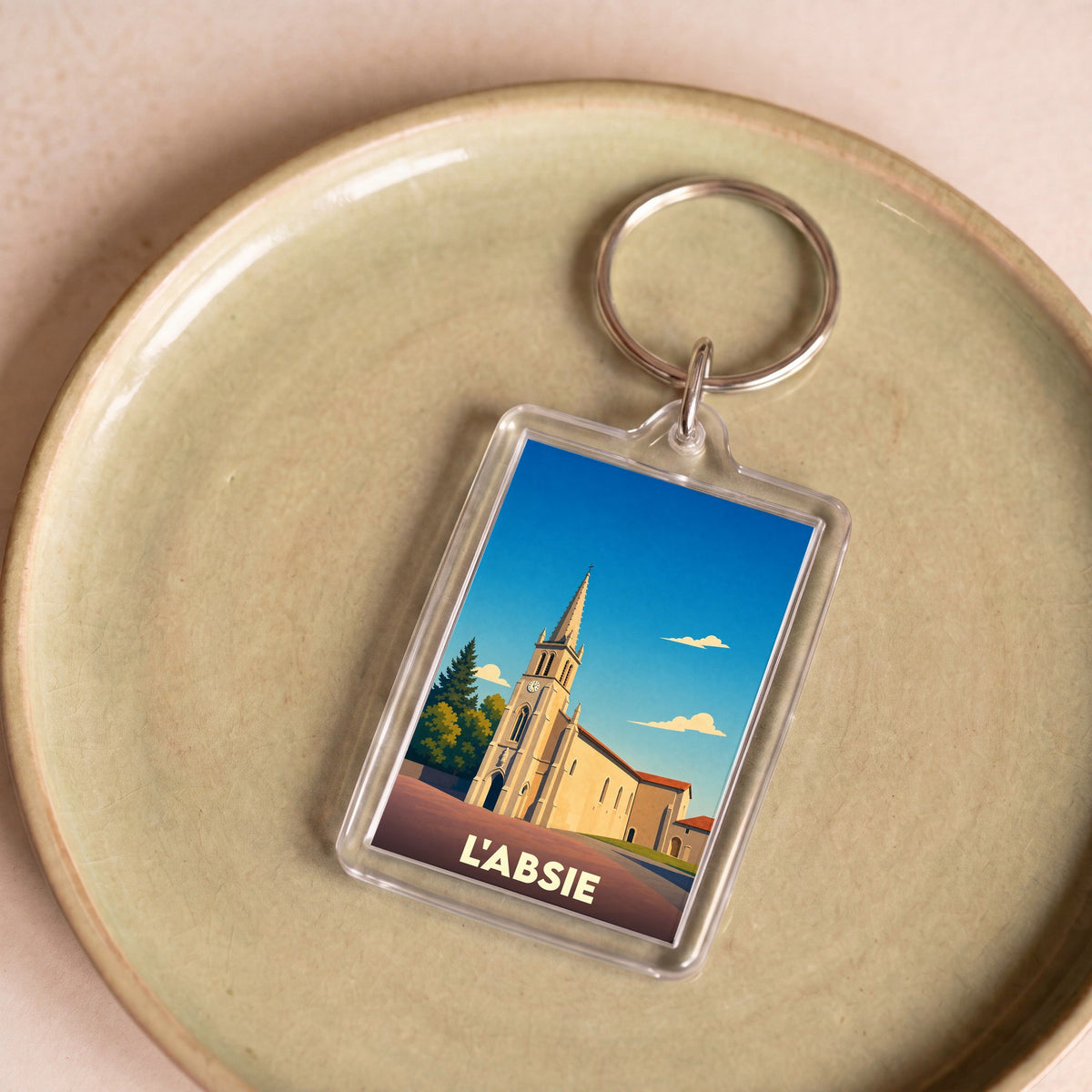 Porte-clés souvenir de la ville de L'Absie avec une illustration stylisée de son église.