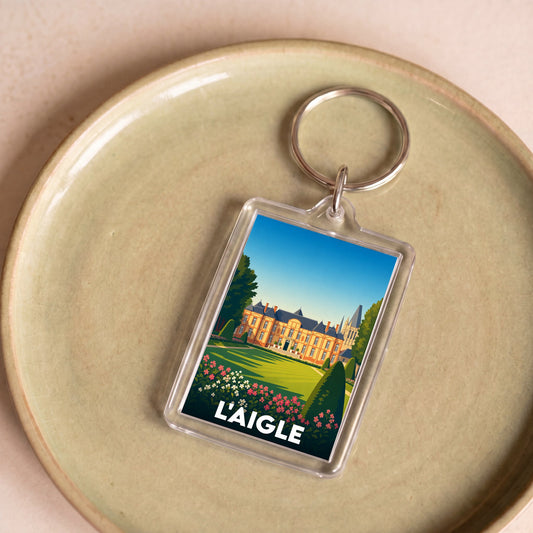 Porte-clés souvenir de la ville de L'Aigle avec une illustration stylisée du château.