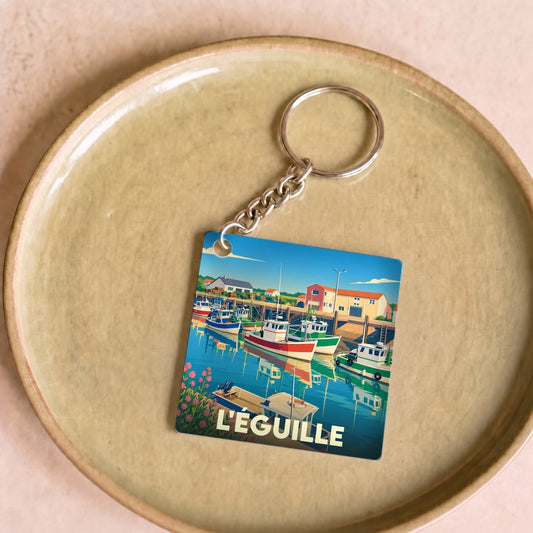 Porte-clés souvenir de la ville de L'Éguille avec une illustration colorée de son port de pêche.