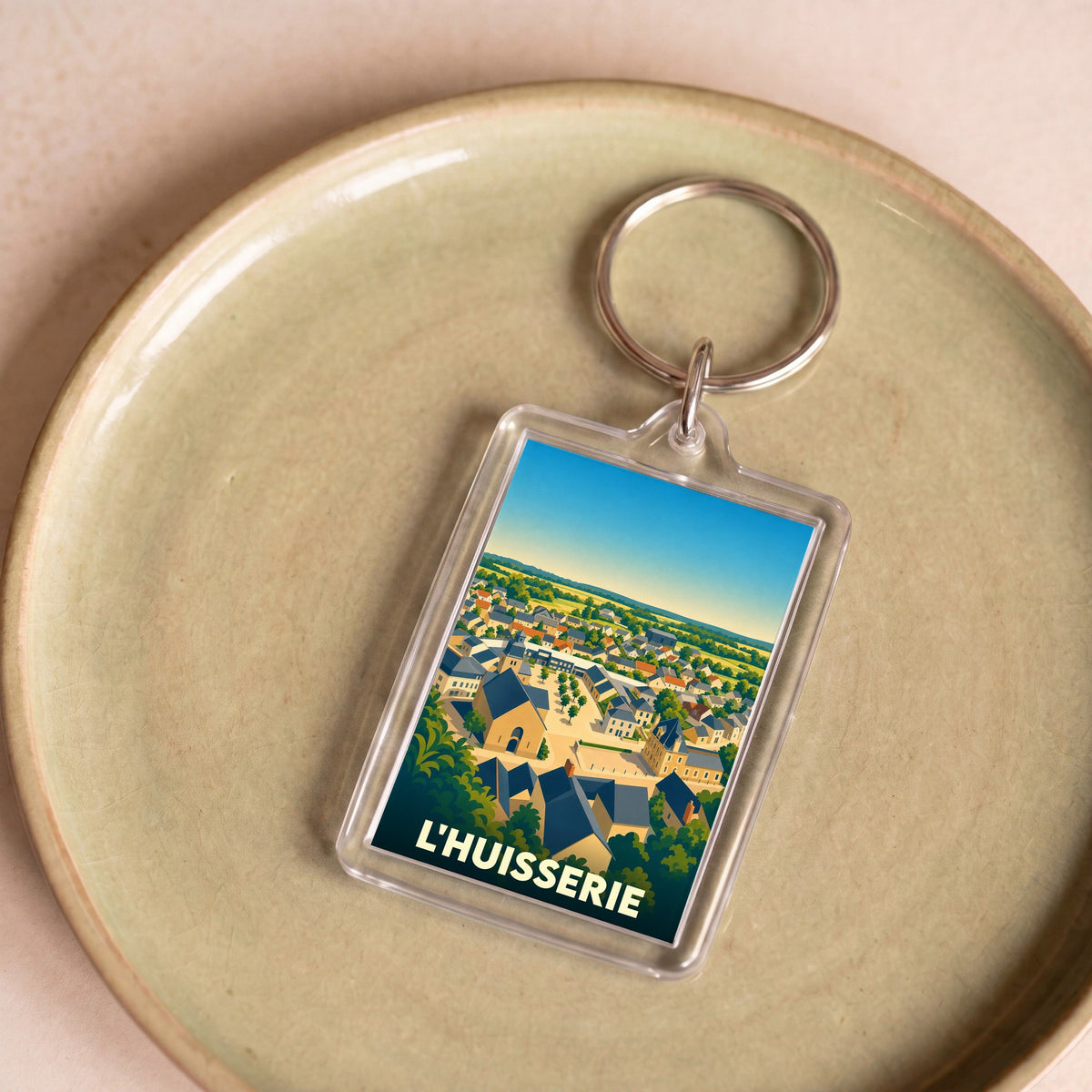 Porte-clés souvenir de la ville de L'Huisserie avec une illustration stylisée.