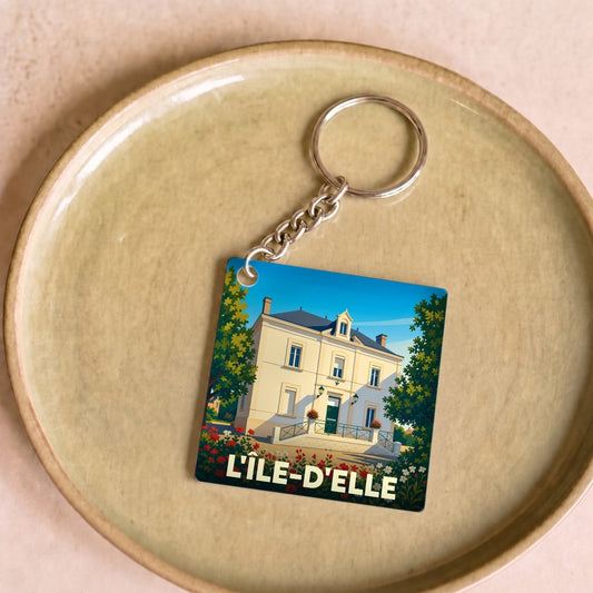 Porte-clés souvenir de la ville de L'Île-d'Elle avec une illustration stylisée d'une grande demeure.