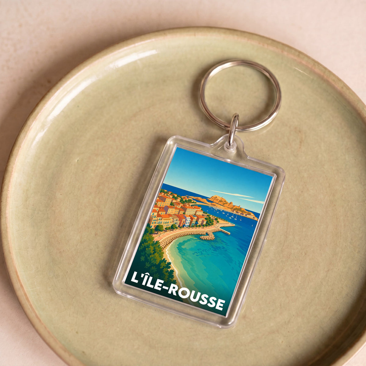 Porte-clés souvenir de la ville de L'Île-Rousse avec une illustration stylisée.