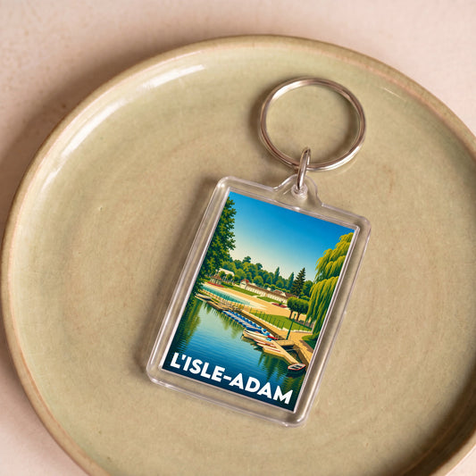 Porte-clés souvenir de la ville de L'Isle-Adam avec une illustration stylisée d'un bord de l'eau.
