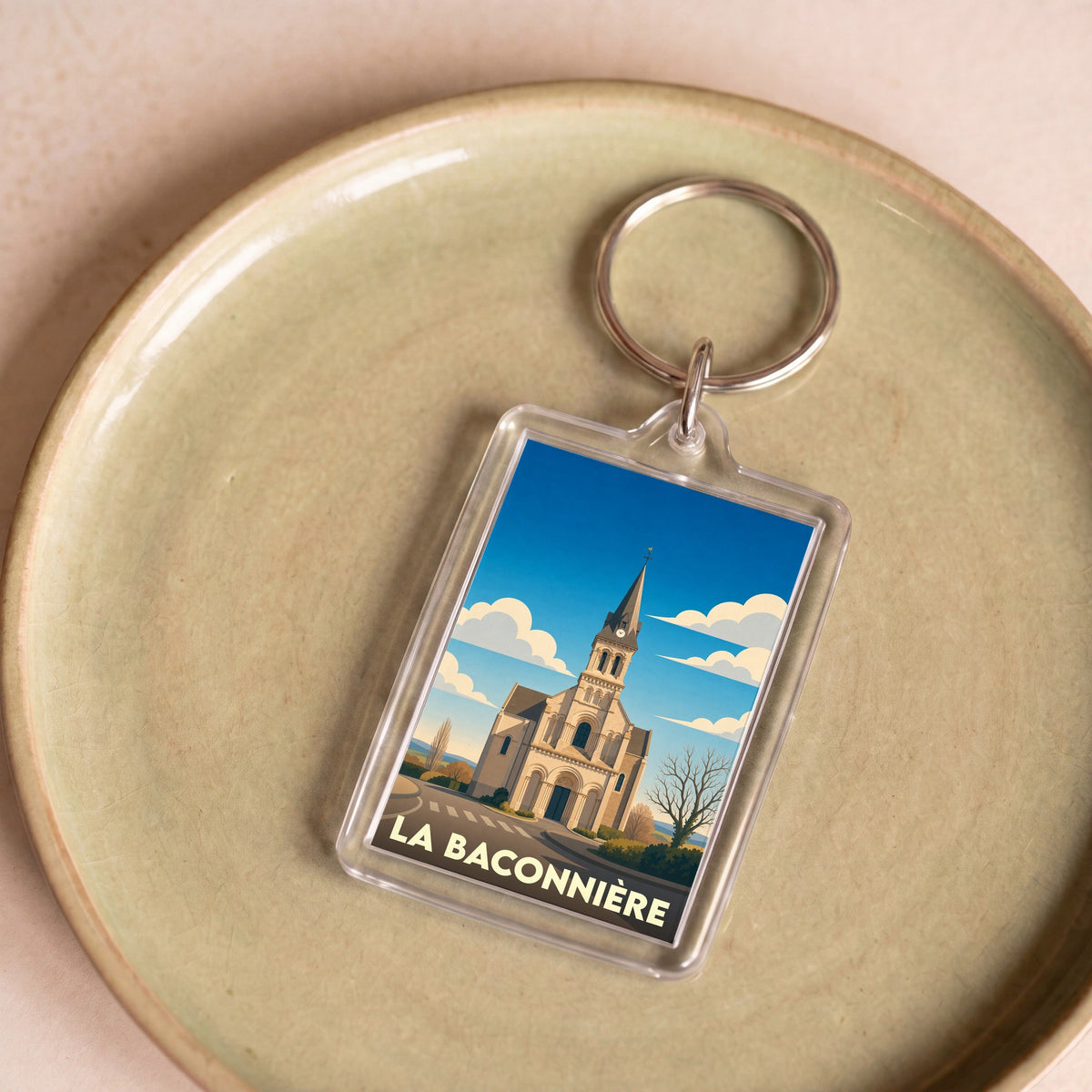 Porte-clés souvenir de la ville de La Baconnière avec une illustration stylisée de son église.