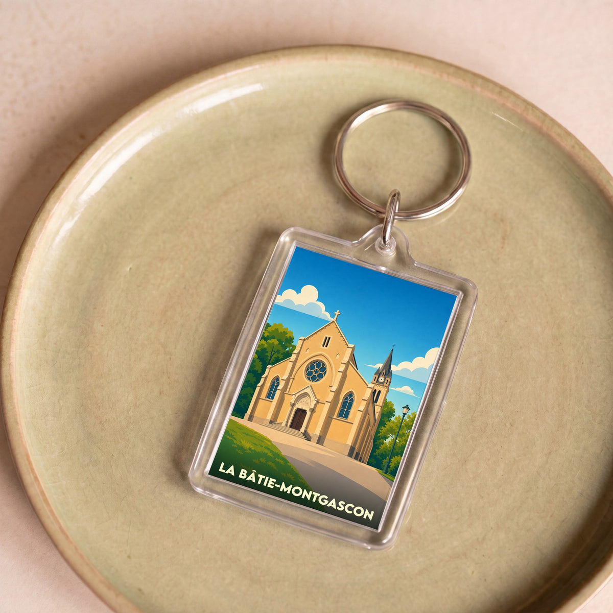 Porte-clés souvenir de la ville de La Bâtie-Montgascon avec une illustration stylisée de son église.