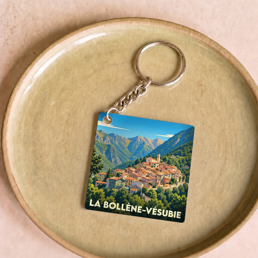 Porte-clés souvenir de la ville de La Bollène-Vésubie avec une illustration stylisée d'un village de montagne.