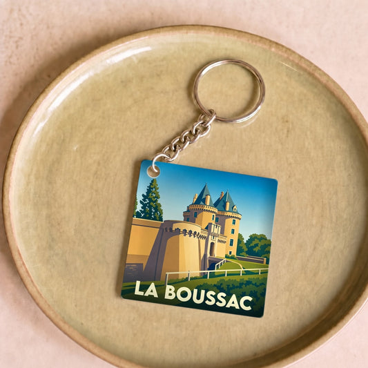 Porte-clés souvenir de la ville de La Boussac avec une illustration stylisée de son château.