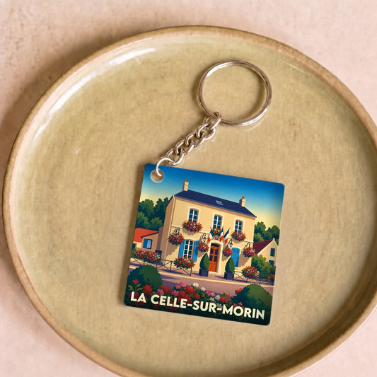 Porte-clés souvenir de la ville de La Celle-sur-Morin avec une illustration stylisée d'une maison fleurie.