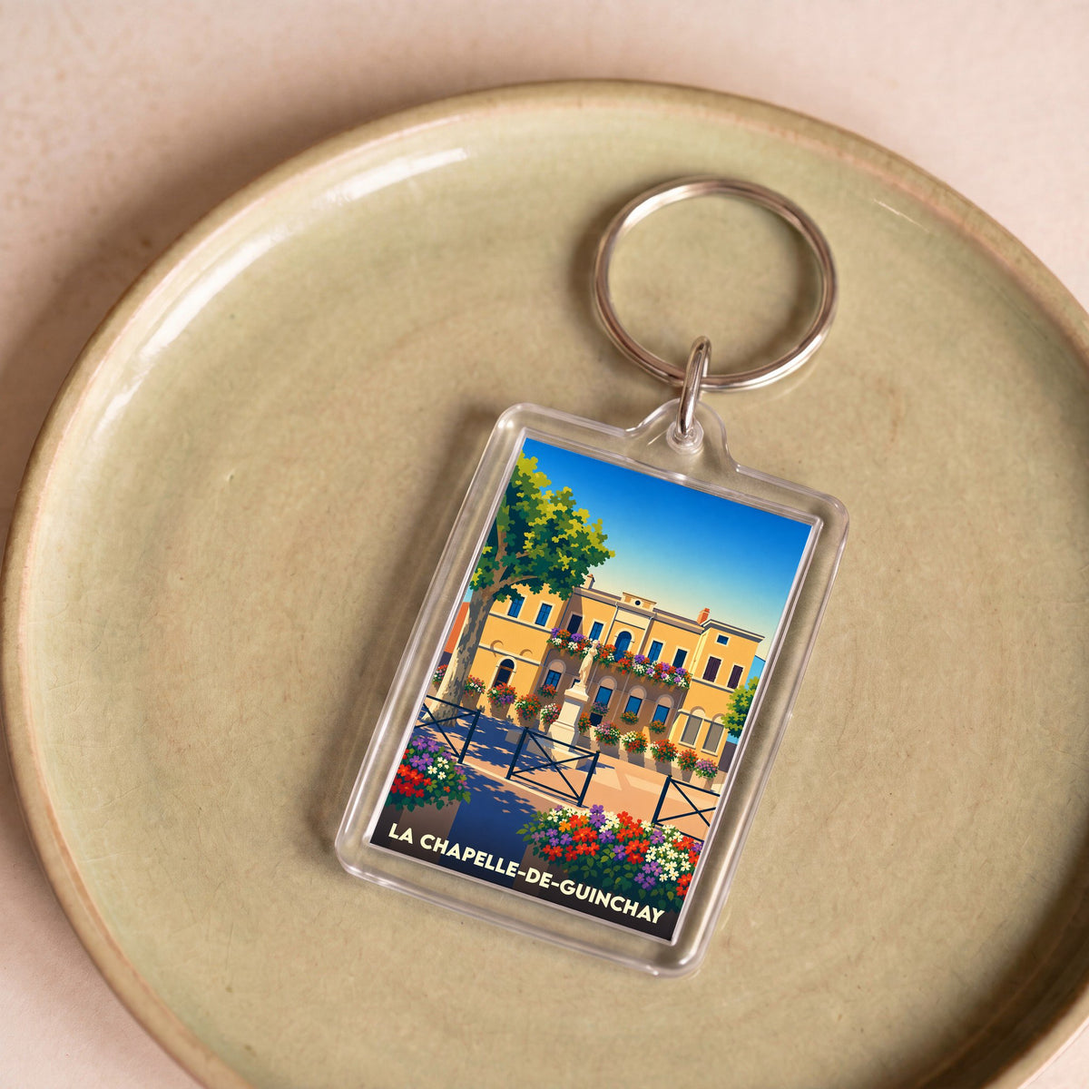 Porte-clés souvenir de la ville de La Chapelle-de-Guinchay avec une illustration colorée et stylisée.