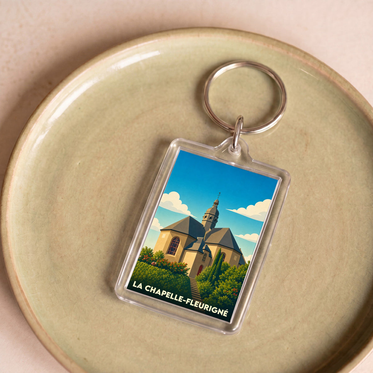 Porte-clés souvenir de la ville de La Chapelle-Fleurigné avec une illustration stylisée de son église.