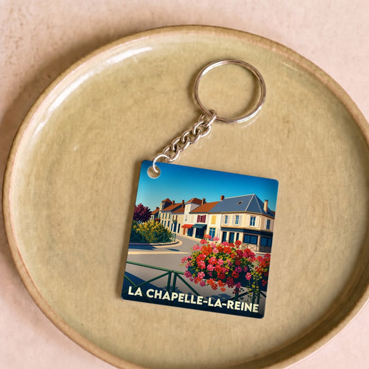 Porte-clés souvenir de la ville de La Chapelle-la-Reine avec une illustration colorée et stylisée.