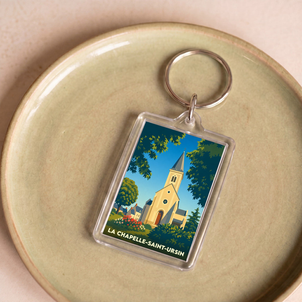 Porte-clés souvenir de la ville de La Chapelle-Saint-Ursin avec une illustration stylisée de son église.
