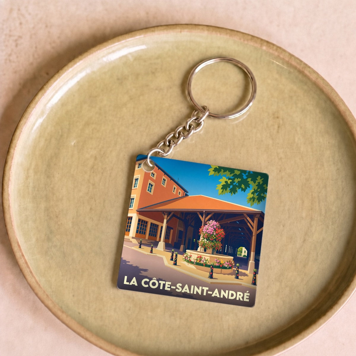Porte-clés souvenir de la ville de La Côte-Saint-André avec une illustration stylisée de ses halles.