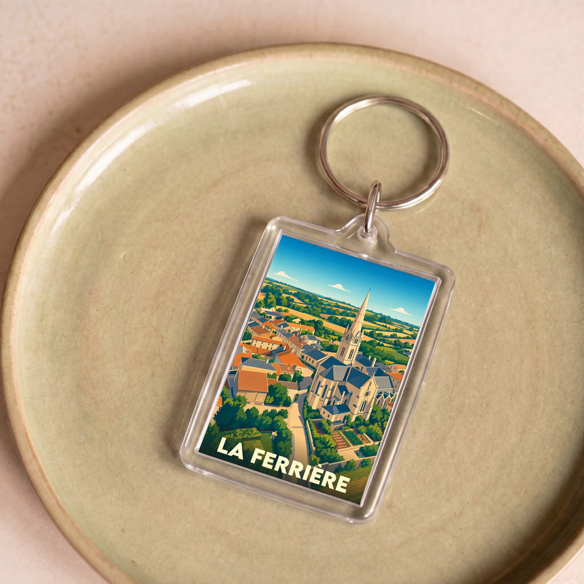 Porte-clés souvenir de la ville de La Ferrière avec une illustration stylisée.