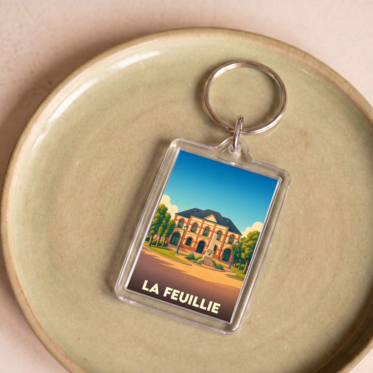 Porte-clés souvenir de la ville de La Feuillie avec une illustration stylisée.