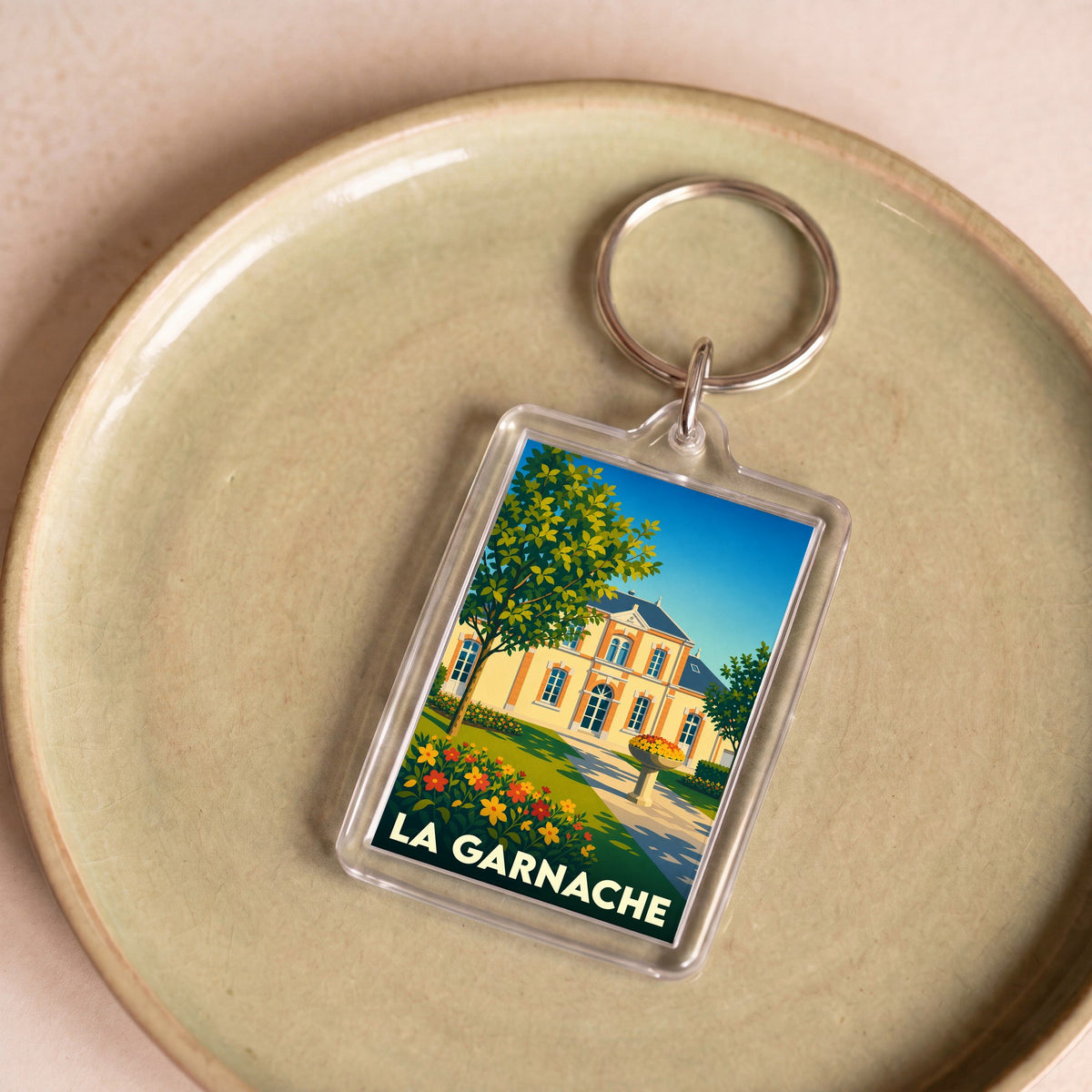 Porte-clés souvenir de la ville de La Garnache avec une illustration stylisée d'un château fleuri.