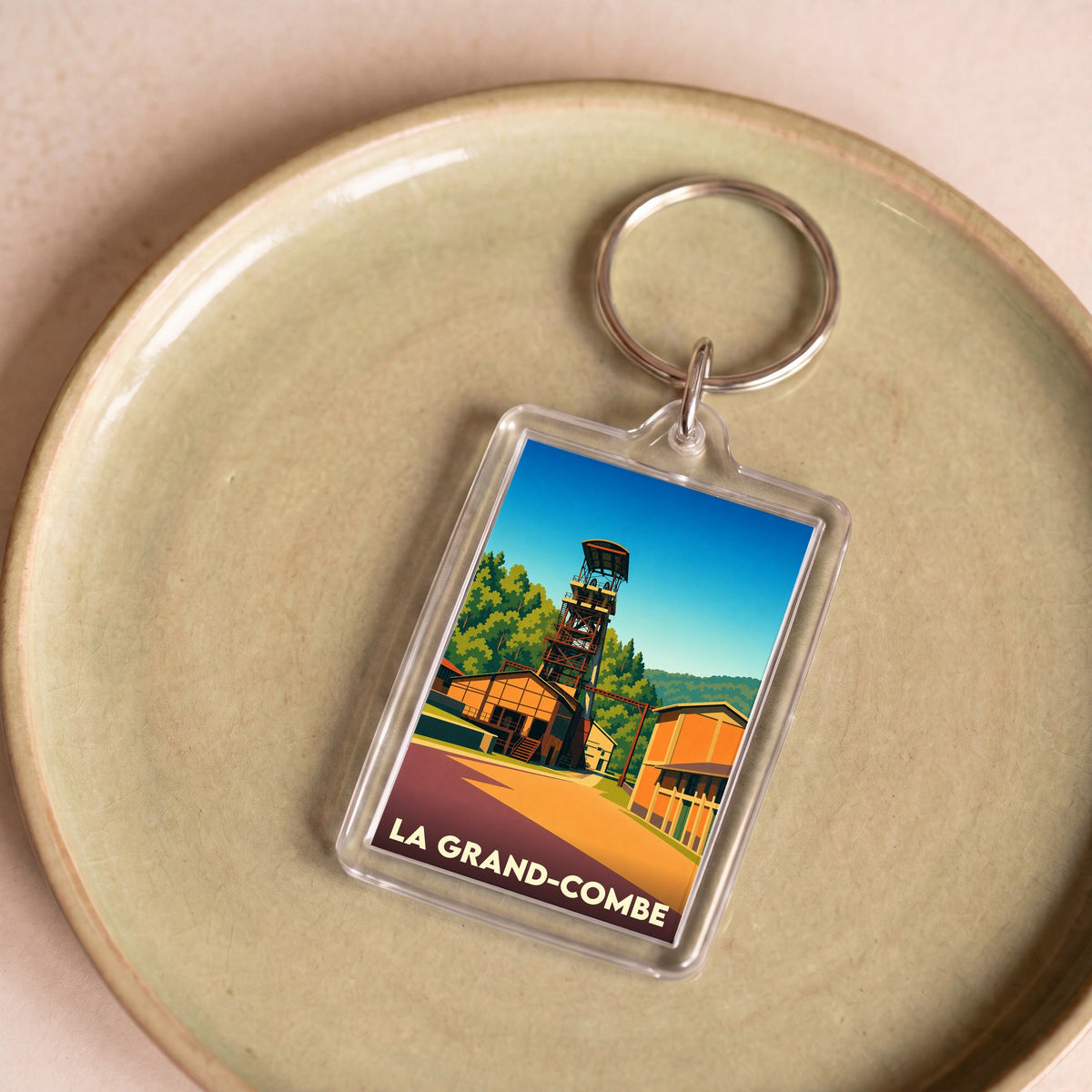 Porte-clés souvenir de la ville de La Grand-Combe avec une illustration stylisée de son chevalement minier.