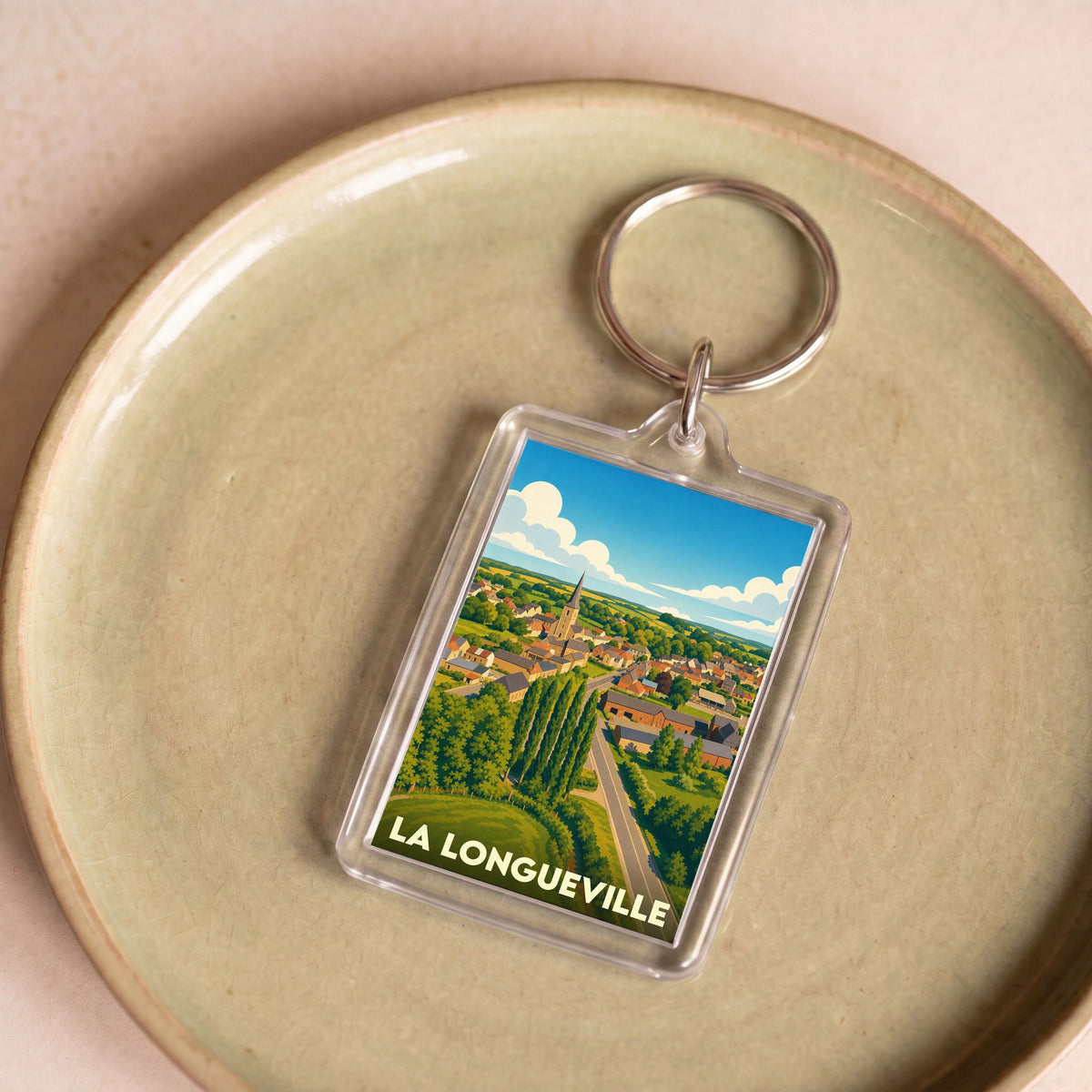 Porte-clés souvenir de la ville de La Longueville avec une illustration stylisée.