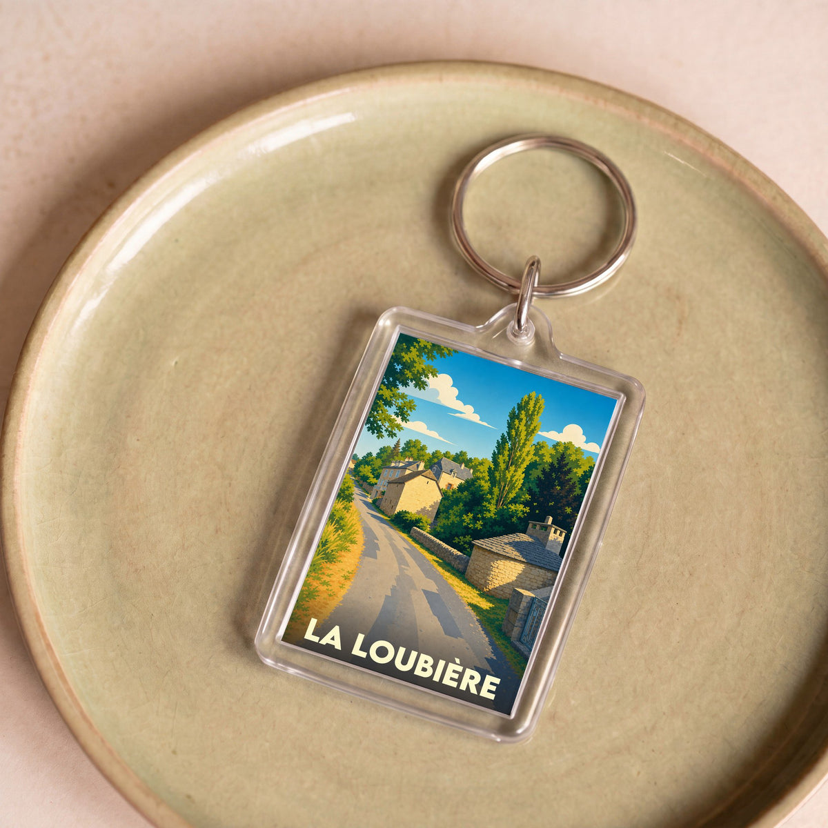 Porte-clés souvenir de la ville de La Loubière avec une illustration stylisée de village.