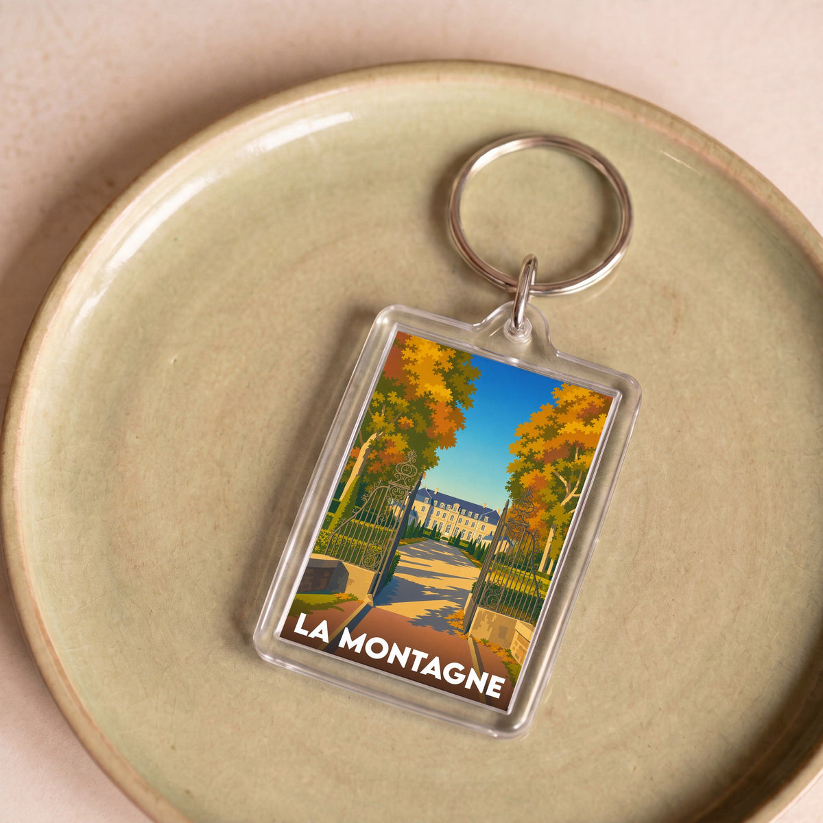 Porte-clés souvenir de la ville de La Montagne avec une illustration stylisée d'un domaine arboré.