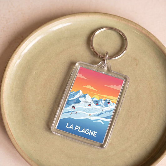 Porte-clés souvenir de la ville de La Plagne avec une illustration stylisée.