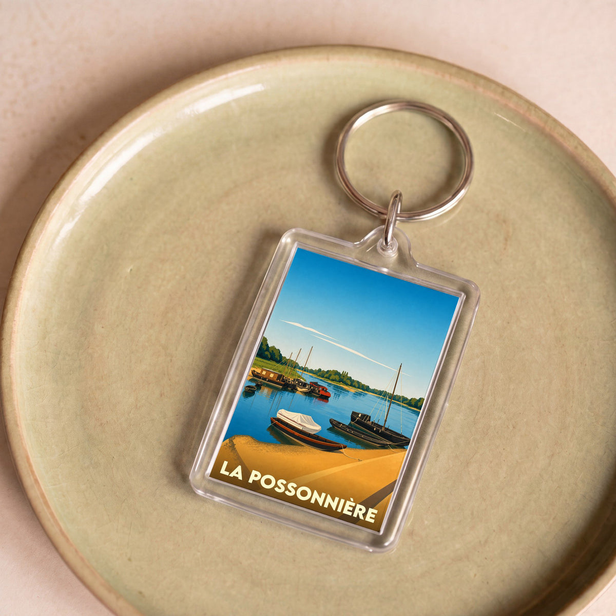 Porte-clés souvenir de la ville de La Possonnière avec une illustration stylisée de bateaux sur la Loire.