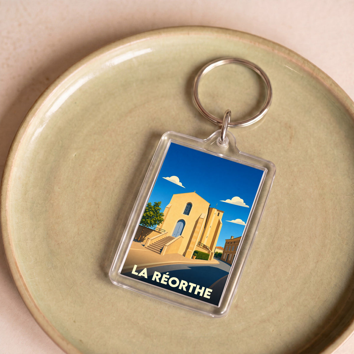 Porte-clés souvenir de la ville de La Réorthe avec une illustration stylisée de son église.