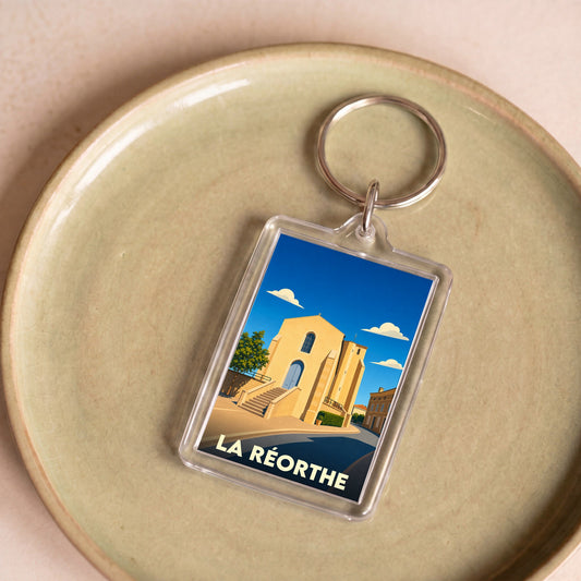 Porte-clés souvenir de la ville de La Réorthe avec une illustration stylisée de son église.