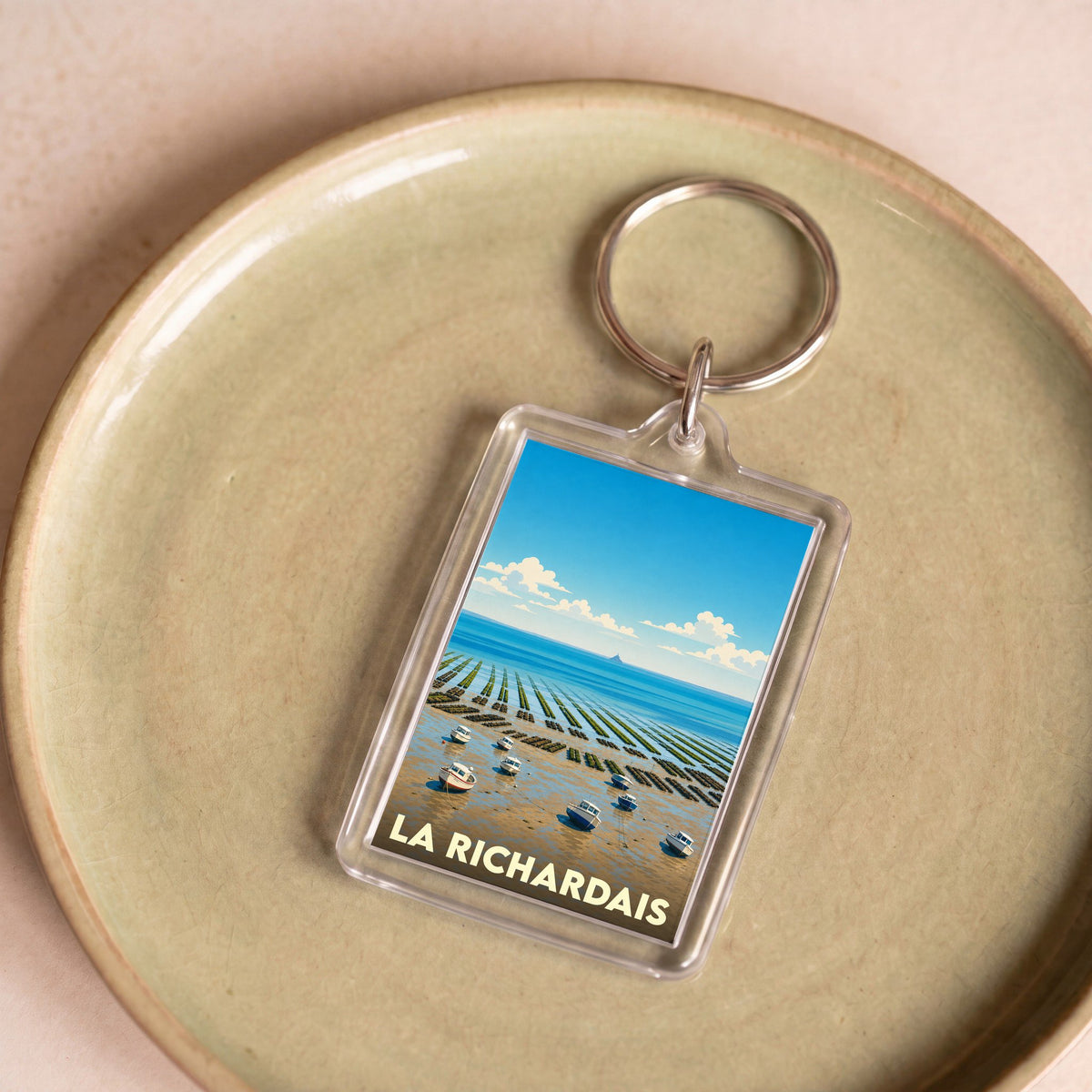 Porte-clés souvenir de la ville de La Richardais avec une illustration stylisée de son paysage côtier.