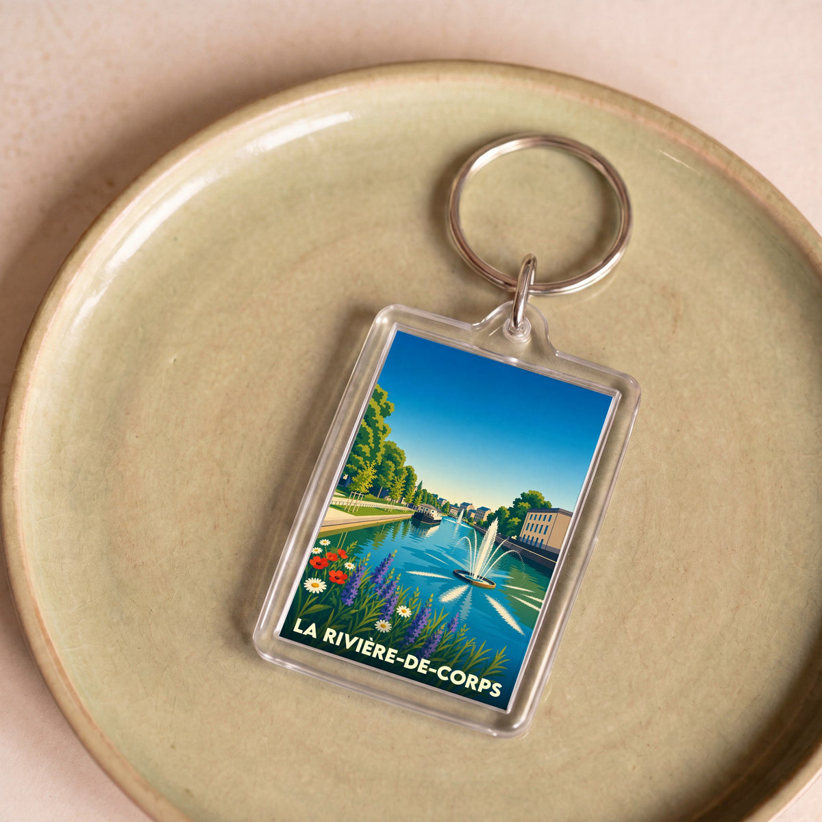 Porte-clés souvenir de la ville de La Rivière-de-Corps avec une illustration stylisée.